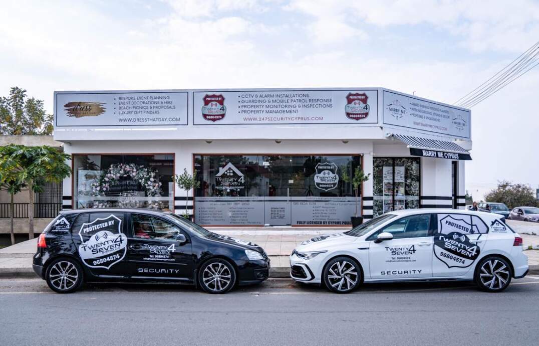 Two branded Twenty4Seven response vehicles parked outside the Paphos premises